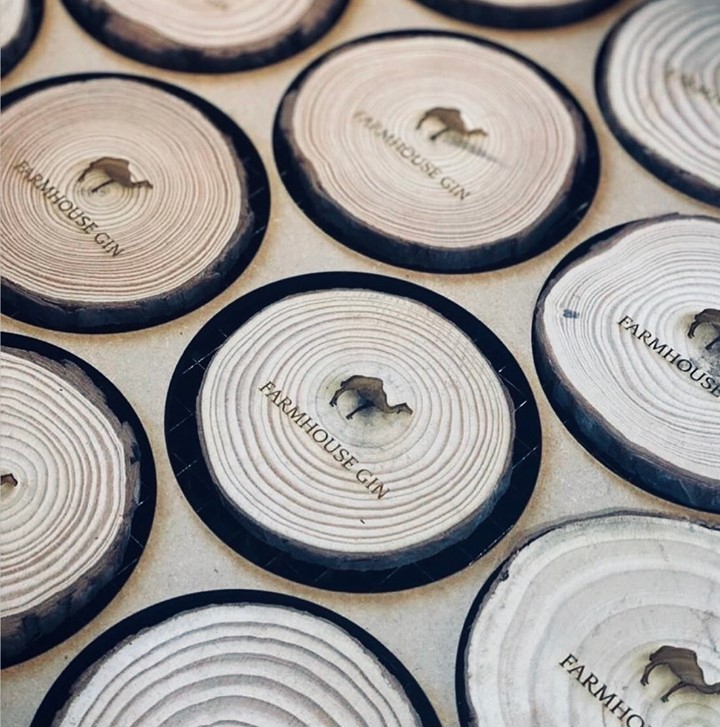 Engraved log slices with the Farmhouse Gin logo