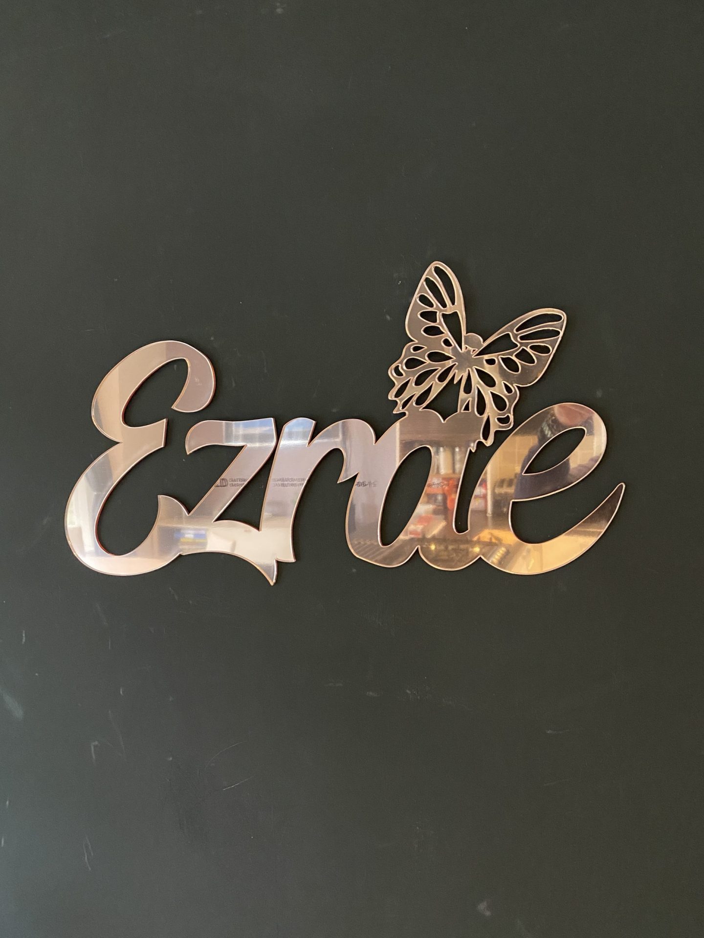 Ezrae Name sign with a butterfly in rose gold mirror acrylic