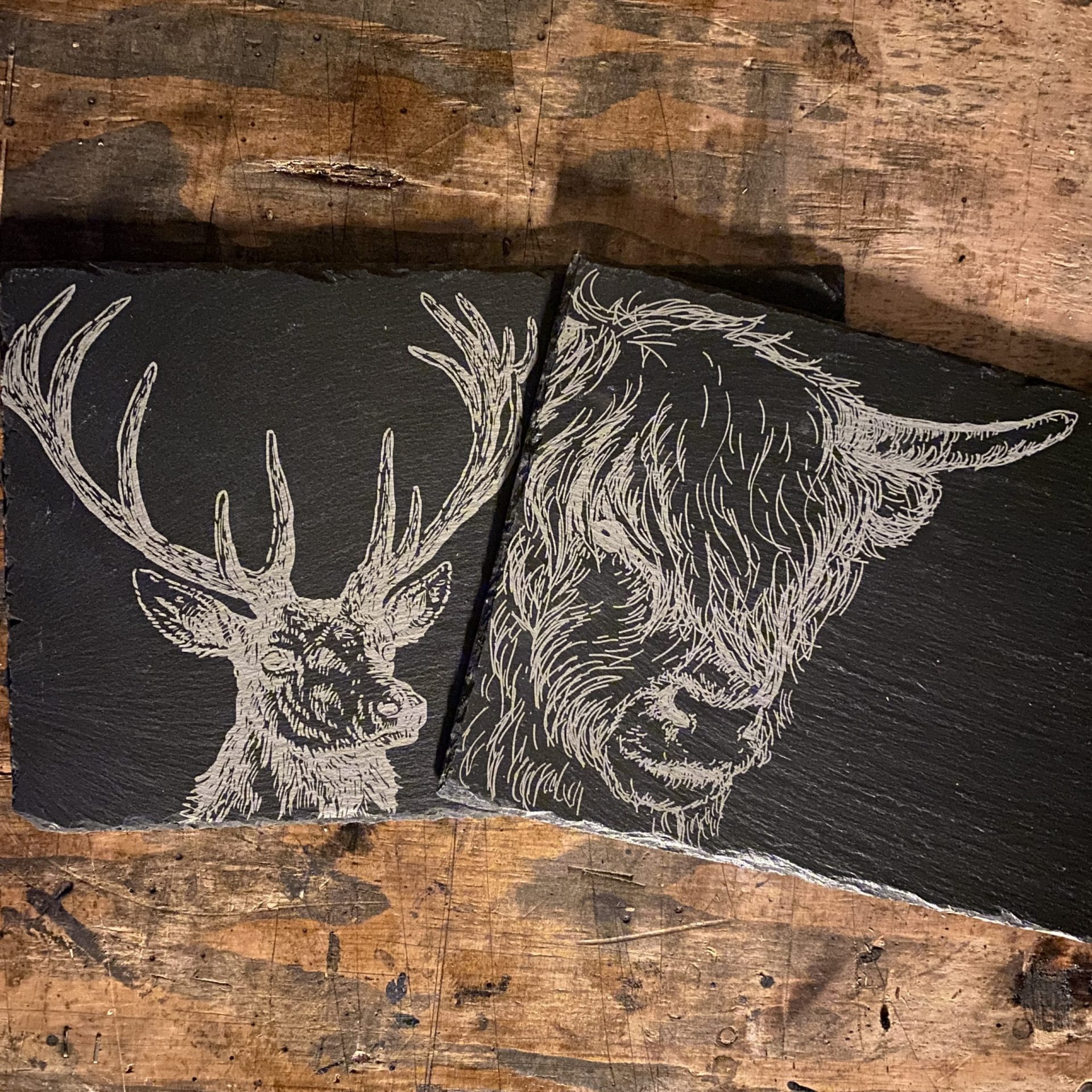 slate placemats laser engraved with a stag and highland cow by the altered state for ellie & hart