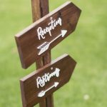 Wedding sign for reception and restrooms with a CNC cut wooden arrow and laser cut acrylic text attached by The Altered State